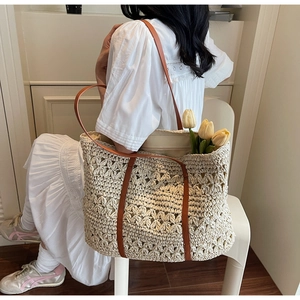 Close-up of hollow straw tote bag with beige geometric pattern and brown leather straps
