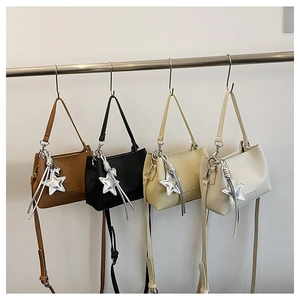 Détails de quatre sacs à main en marron, noir, jaune et beige avec pendentifs en étoile