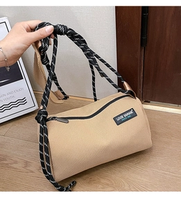 Detail of khaki mesh Boston crossbody bag with sporty black and white rope shoulder strap