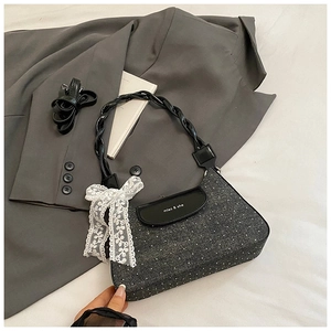 Detail of grey polka dot tweed bag with leather flap and lace bow decoration