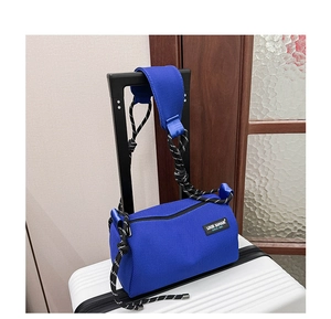 Close-up of bright blue honeycomb texture cylinder bag on white luggage in a travel setting