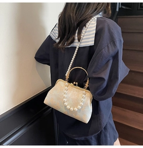 Detailed view of Chinese style pearl embroidery handbag with elegant gold metal frame