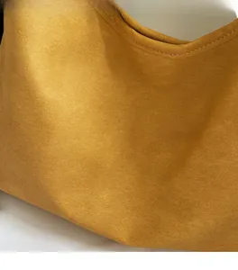 Close-up of ginger yellow tote bag showing soft canvas fabric and neat white stitching