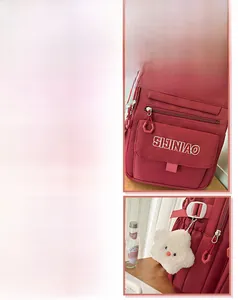 Detailweergave van rode nylon rugzak met SJNBAO-logo en een witte pluche sterrenhanger