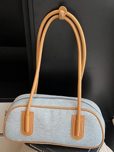 Vintage denim bowling handbag with tan leather trim and long shoulder straps