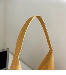 Detail of a bright yellow tote bag showing wide comfortable straps and fabric texture