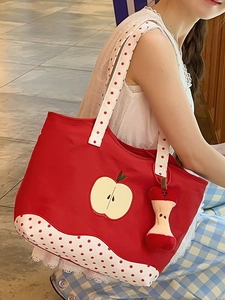 Red canvas apple tote bag with polka dot straps and a cute plush charm for women