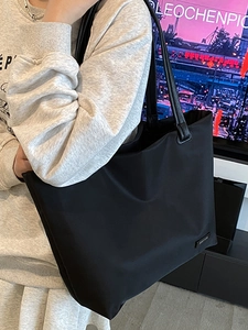 Minimalist black large capacity tote bag shown on model for daily commuting style