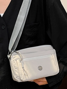 Chic light grey nylon crossbody camera bag with wide strap and multi-zipper pockets