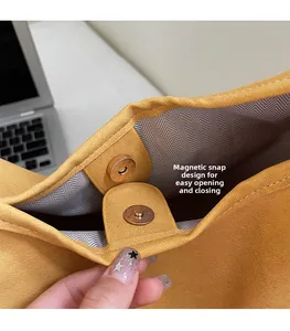 Detail of the magnetic snap closure on a yellow tote bag with zigzag patterned lining