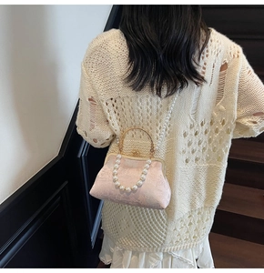 Pink jacquard floral handbag detail with gold handle and elegant pearl chain strap