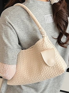 Handwoven cream beige shoulder bag with thick strap shown in an elegant lifestyle pose
