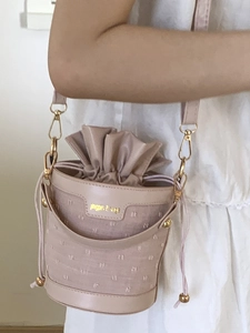Sac seau chic rose clair avec fermeture à cordon et détails métalliques dorés