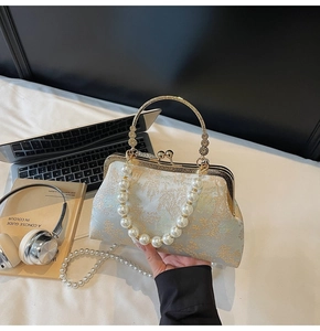 Close-up of vintage pearl embroidery handbag with light blue satin and gold floral jacquard
