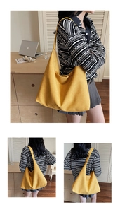 Detailed close-up of large yellow hobo shoulder bag showing soft fabric and wide strap