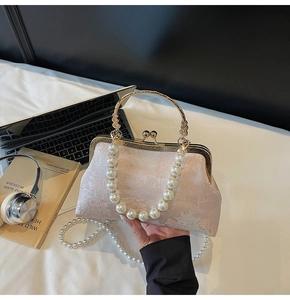 Close-up of pink jacquard handbag with pearl handle and traditional Chinese embroidery