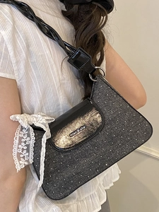 Polka dot tweed underarm bag with black patent leather strap and white lace bow accessory