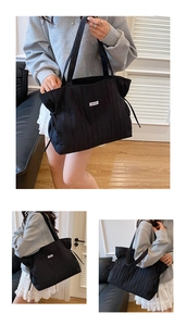Détail du grand sac cabas noir avec texture plissée et cordons de serrage réglables sur le côté