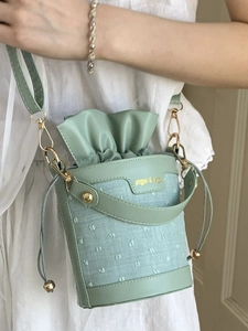 Sac seau moderne vert clair en cuir et tissu avec cordon et bandoulière en métal