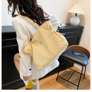 Détail du cabas plissé jaune clair avec nœuds à cordon et texture douce au toucher