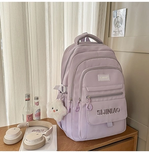 Detailopname van lila nylon schoolrugzak met meerdere vakken en pluche sterrenhanger