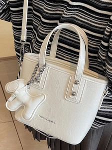 Chic white pleated leather bucket bag with puppy charm and silver chain strap