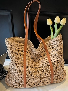 Minimalist beige hollow woven straw tote bag with brown leather shoulder straps