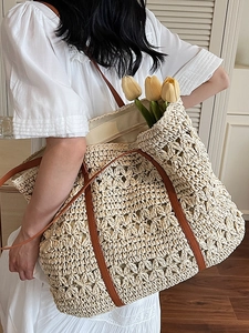 Hollow straw tote bag with brown leather handles for summer beach vacations and travel