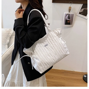 Détail du sac cabas plissé blanc montrant la texture du tissu et le cordon de serrage