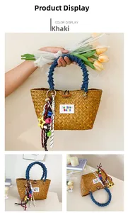 Detail of hand-woven straw tote bag with denim handles and colorful fashion embroidery