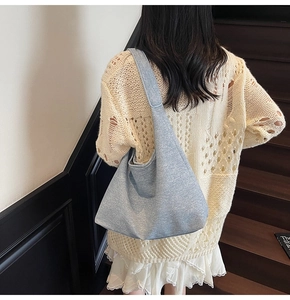 Detail of light blue hobo bag showing large capacity and textured fabric on shoulder