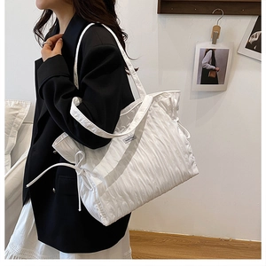Détail du sac fourre-tout blanc matelassé avec nœud de serrage et fines bretelles