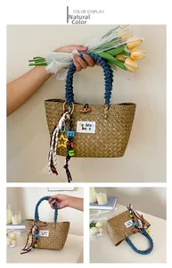 Detail view of woven straw basket bag with denim handles and decorative charms