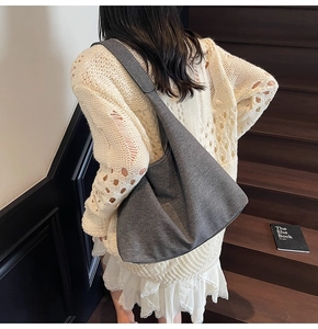 Detail view of dark grey canvas tote bag showing the textured fabric and wide shoulder strap