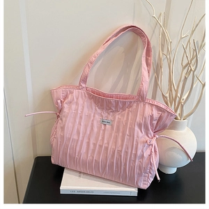 Détail du sac cabas plissé rose avec nœuds coulissants et étiquette décorative