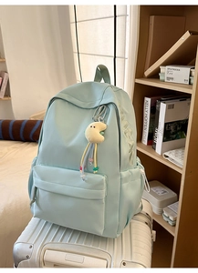 Detail eines hellblauen Schulrucksacks mit NIJMBAG-Stickerei und Mond-Plüschanhänger
