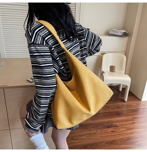 Lifestyle shot of large mustard yellow canvas hobo tote bag with wide shoulder strap