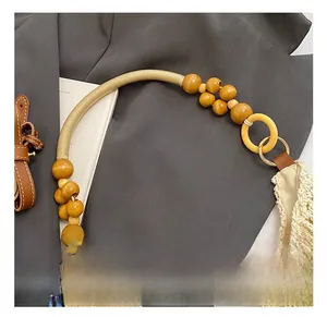 Detail of hand-woven straw bag featuring wooden beads and comfortable rope handle