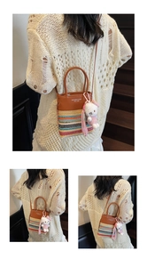 Tre viste di una borsa a secchiello in tessuto a righe con manici in pelle e charm