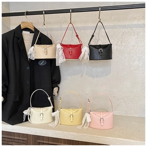 Vue détaillée de six sacs seaux tissés colorés avec pendentifs en dentelle et perles