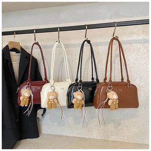 Détail de la texture cuir et marquage COIN SDN avec de mignons pendentifs oursons