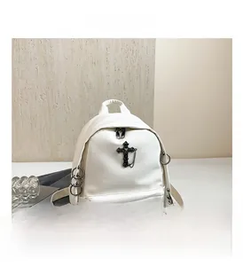 Detail of white punk style backpack showing black metal cross and ring accessories
