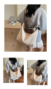 Detail view of large canvas tote bag with brown leather trim and shoulder strap