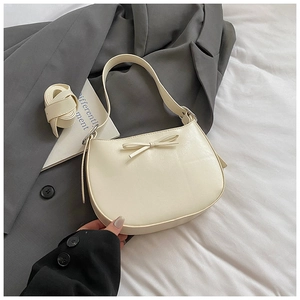 Vue détaillée du sac sous le bras beige en forme de croissant avec un nœud élégant