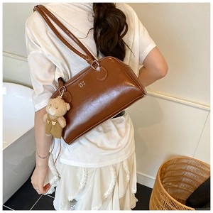 Détail du sac à bandoulière en cuir PU marron brillant avec ours en peluche et anses