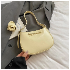 Détail du sac hobo jaune clair avec nœud et bandoulière amovible sur blazer gris