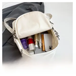 Detail showing the large storage capacity of the white leather backpack with various items