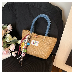 Detailed shot of handmade straw bag with denim handles and colorful star charms