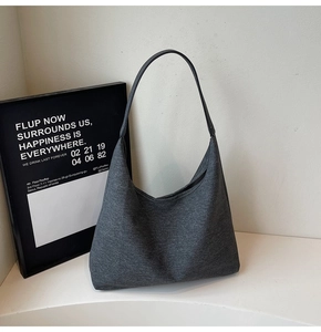 Close-up of dark grey textured fabric on a minimalist large capacity shoulder tote bag