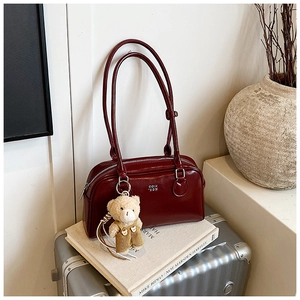 Sac Boston rouge foncé en similicuir brillant avec un joli petit ours en peluche